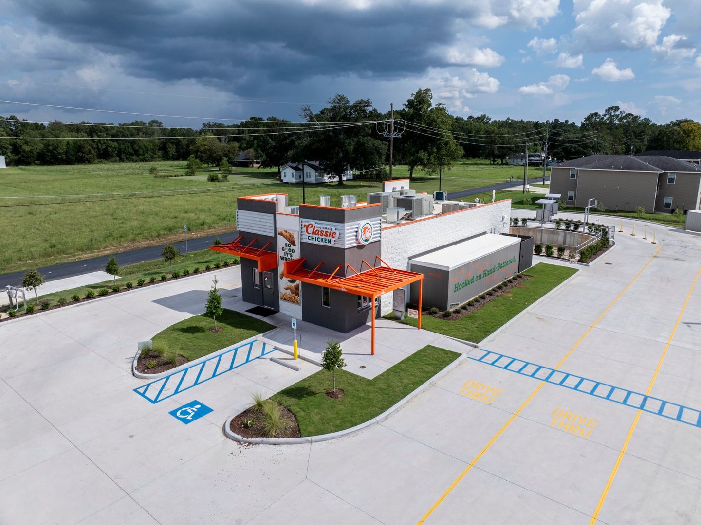 Finished restaurant with the orange walk-up canopy and wrapped drive-thru lane