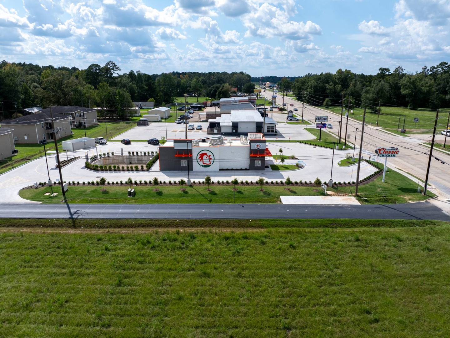 Completed site seen from across the road: landscaping, drive-thru loop and pylon sign