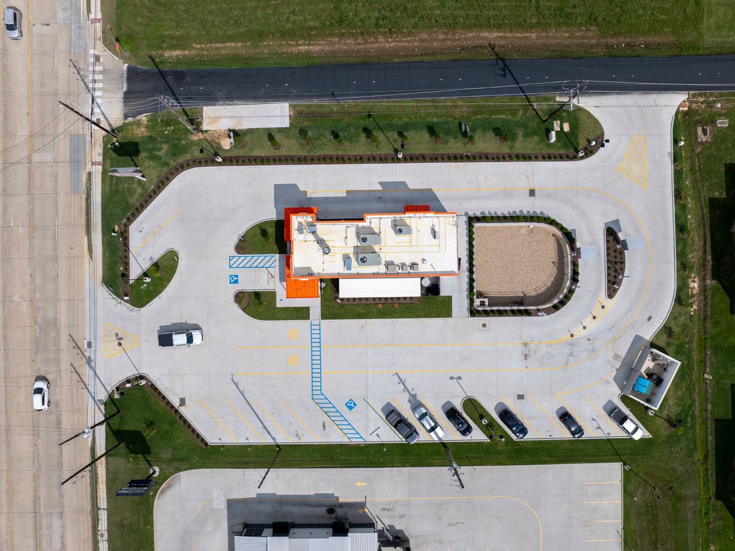 Overhead drone view of the completed site: building, drive-thru loop, parking and stormwater basin