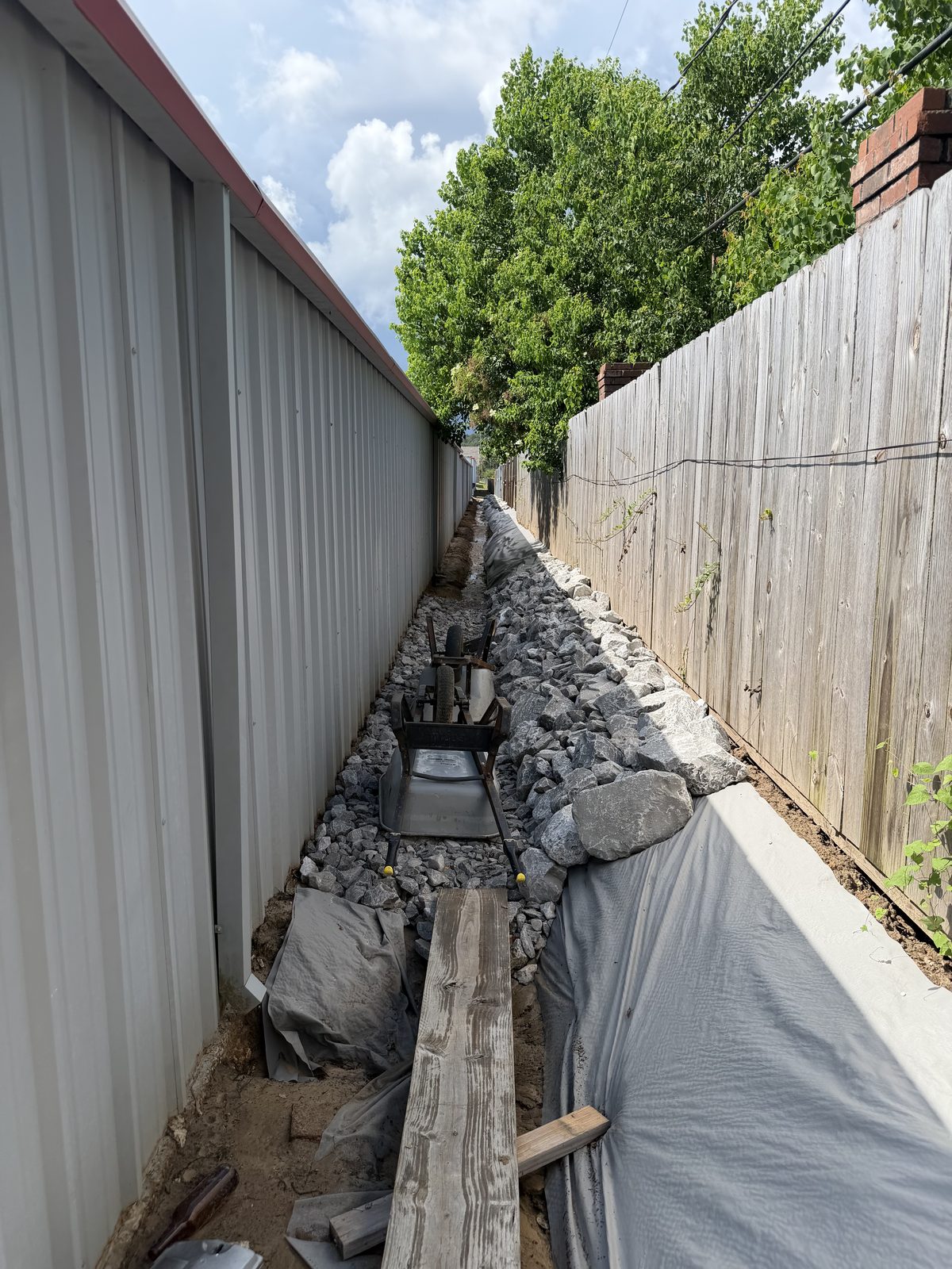 Drainage stone being placed and compacted in the channel